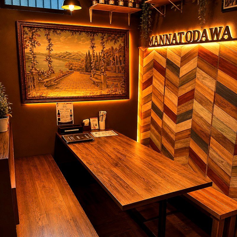 Private booth with framed artwork and herringbone wall at Mannat